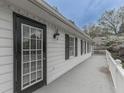 Side view of home showing porch with white railing, black shutters, and black door at 1606 Nuthatch Ct, Marietta, GA 30062