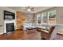 Cozy living room with fireplace, wood accent wall, and large windows at 587 Jody Pl, Lilburn, GA 30047