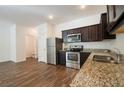 Modern kitchen featuring stainless steel appliances, granite countertops, and dark wood cabinets at 1837 Millstream Holw, Conyers, GA 30012