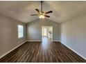Inviting living room with a modern ceiling fan and attractive wood-look floors, bathed in natural light at 118 Dove Lndg, Social Circle, GA 30025