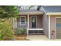 A welcoming front porch with a black door, white railings, and steps, creating a cozy entrance to the home at 5415 Keithwood Dr, Cumming, GA 30040
