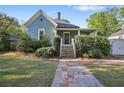 Inviting home with stone pathway leading to a covered porch, enhanced by neatly trimmed hedges and a green lawn at 176 Stewart Nw Ave, Marietta, GA 30064