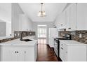 Bright kitchen features white cabinets, granite countertops, tiled backsplash, and stainless steel appliances at 2865 Maple Vista Ln, Lawrenceville, GA 30044