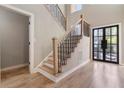 Bright foyer featuring hardwood floors, stairs with black railings, and a modern front door with glass panels at 6960 Dockbridge Way, Stone Mountain, GA 30087