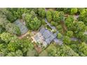 Stunning aerial view of estate with pool, tennis court and lush, mature landscaping offering a private and serene setting at 440 Old Homestead Trl, Johns Creek, GA 30097