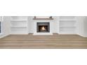 Open living room featuring a modern fireplace, built-in shelves, and hardwood flooring at 1 N Boundary Nw Pl, Atlanta, GA 30318