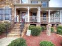Inviting front porch with stone stairs, elegant columns, and manicured landscaping at 5610 Hollowbrooke Ln, Acworth, GA 30101