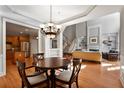 Open dining room with hardwood floors and chandelier, adjacent to kitchen at 12120 Dancliff Trce, Alpharetta, GA 30009