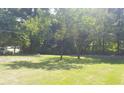 Expansive front yard features lush green grass and mature trees, creating a serene setting at 1256 E Piedmont Rd, Marietta, GA 30062