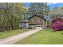 Split-level home with a well-manicured lawn, driveway, and blossoming azaleas at 570 Bell Se Rd, Conyers, GA 30094