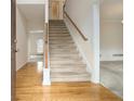 Bright foyer features hardwood floors, stairs with wood banister, and an entry to the living area at 6028 Connaught Se Dr, Mableton, GA 30126