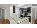 Modern kitchen with granite countertops, stainless steel appliances, and dark wood cabinetry at 1250 Parkwood Se Cir # 2201, Atlanta, GA 30339