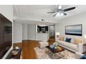 Bright living room featuring hardwood floors, a ceiling fan, and a view of the kitchen at 1250 Parkwood Se Cir # 2201, Atlanta, GA 30339
