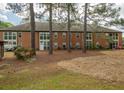 Property backyard showing trees, green grass, and a partial view of a brick building at 310 Brittany Ct, Duluth, GA 30096