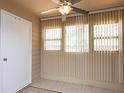 Bright sunroom featuring a ceiling fan, vertical blinds, tile flooring, and access to a door at 310 Brittany Ct, Duluth, GA 30096
