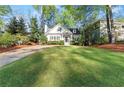 Well-maintained lawn with a cozy traditional-style home nestled among mature trees and landscaping at 2930 Ringle Rd, Brookhaven, GA 30341