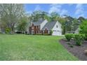 Two-story home with a well-maintained lawn and a two-car garage, offering ample space and classic charm at 4950 Willow Creek Dr, Woodstock, GA 30188