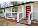 Close-up of a front porch featuring white railings, a striking red door, and well-maintained landscaping at 2190 Highview Rd, Atlanta, GA 30311