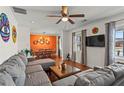 Cozy living room featuring a plush gray sectional sofa, decorative curtains, and unique wall decor at 2984 Bayard St, East Point, GA 30344