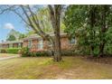 A cozy brick home with well-kept landscaping, surrounded by mature trees, offering a serene setting at 1387 Church St, Decatur, GA 30030