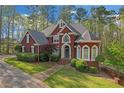 Beautiful brick home showcasing lush landscaping, a well-kept lawn, and elegant architectural details at 240 River Cove Mdws, Social Circle, GA 30025