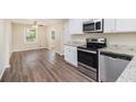Modern kitchen featuring stainless steel appliances, granite countertops, and white cabinets at 293 Howell Sw Dr, Atlanta, GA 30331