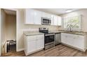 Well-lit kitchen with white cabinets, granite countertops, and stainless steel appliances at 293 Howell Sw Dr, Atlanta, GA 30331