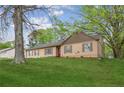 A quaint single-story home with a manicured green lawn and mature trees in a quiet setting at 140 Apple Valley Dr, Woodstock, GA 30188