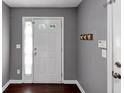 Neutral gray entryway with wood floors, a white front door and coat hooks at 2180 Mill Garden Run, Buford, GA 30519
