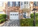 Brick townhome with a white garage door and dark blue front door at 2180 Mill Garden Run, Buford, GA 30519