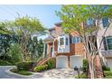 Beautiful brick townhouse with a two-car garage, bay window, and manicured landscaping on a sunny day at 5888 Riverstone Cir # 15, Atlanta, GA 30339