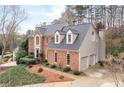 Beautiful two-story brick home with attached two car garage, dormers, and mature landscaping at 205 Wellesley Ct, Woodstock, GA 30189