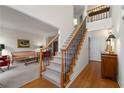 Open and inviting entry foyer with hardwood floors, stairway, and access to living room at 205 Wellesley Ct, Woodstock, GA 30189