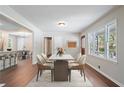Sunlit dining room with hardwood floors, a modern table set, and a large window that provides an outdoor view at 2125 Perkerson Mill Rd, Austell, GA 30106