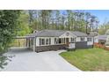 Charming home with a covered parking area, well-maintained landscaping, and a freshly painted driveway at 2125 Perkerson Mill Rd, Austell, GA 30106