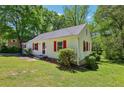 Cozy home with red shutters surrounded by mature trees and a lush green lawn at 2488 Glendale Se Cir, Smyrna, GA 30080