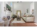 Bright living room featuring high ceilings, fireplace, hardwood floors, and an oversized decorative mirror at 155 Glenside Ln, Duluth, GA 30097