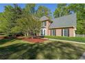 Traditional brick home with black shutters, lush lawn, and fresh landscaping at 6221 Woodlore Nw Dr, Acworth, GA 30101
