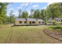 Charming yellow home with a well-kept lawn and ample space surrounded by lush trees at 175 Springvalley Way, Stockbridge, GA 30281