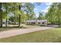 Street view of a quaint yellow house with a well-maintained lawn and a long driveway at 175 Springvalley Way, Stockbridge, GA 30281