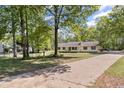 Lovely yellow house on a large lot featuring mature trees and a long private driveway at 175 Springvalley Way, Stockbridge, GA 30281