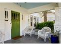 Inviting front porch featuring white wicker chairs and a charming green front door at 3120 Church St, Atlanta, GA 30344