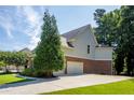 Side view of the home featuring a two-car garage and well-maintained lawn and landscaping at 510 Towneside Ln, Marietta, GA 30064