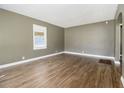 Spacious living room with hardwood floors, neutral paint, and natural light from the window at 1958 Long Dr, Decatur, GA 30032