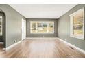 Sunlit living room with hardwood floors, neutral walls, and large windows offering a view of the yard at 1958 Long Dr, Decatur, GA 30032