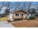 Well-maintained home with covered porch, wooden columns, and a new fence defining the property line at 984 Manor Se Dr, Smyrna, GA 30080