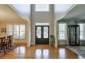 Grand foyer with gleaming hardwood floors, a double-door entry, and views into the dining and living rooms at 205 Northampton Ct, Canton, GA 30115