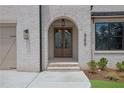 Inviting entryway showcases the archway, wood doors, and manicured shrubbery at 380 Hillcrest View Dr, Suwanee, GA 30024