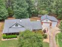 Aerial view of a home with a large lot, detached garage, and mature trees at 219 Riverbrook Ct, Mcdonough, GA 30252