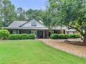 Charming single-story home with manicured lawn, mature trees, and inviting front porch at 219 Riverbrook Ct, Mcdonough, GA 30252